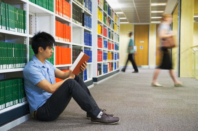 Chinese student in a library reading and learning